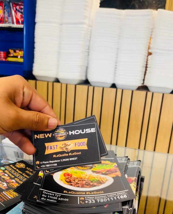 Cartes de visite et menus de New Tacos House présentés au comptoir.